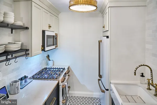 a kitchen with a sink a stove and a refrigerator