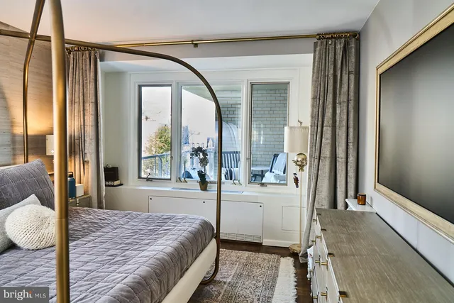 a bedroom with a bed and a large window with outer view