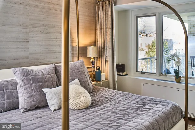 a bedroom with a bed and large windows