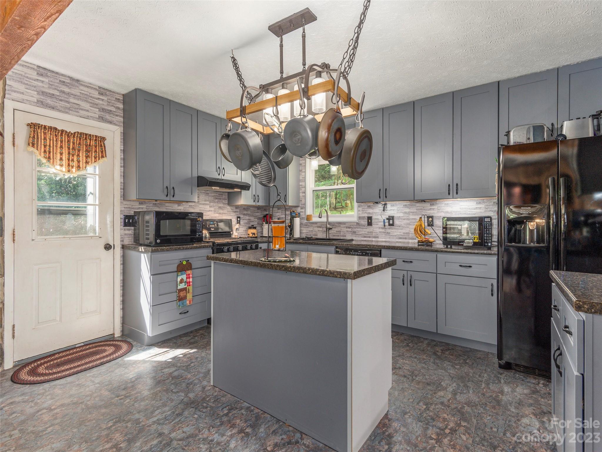 291 Dickinson Drive Clyde, NC 28721 - Photo 6 of 27 a kitchen with kitchen island granite countertop a sink cabinets a window and stainless steel appliances