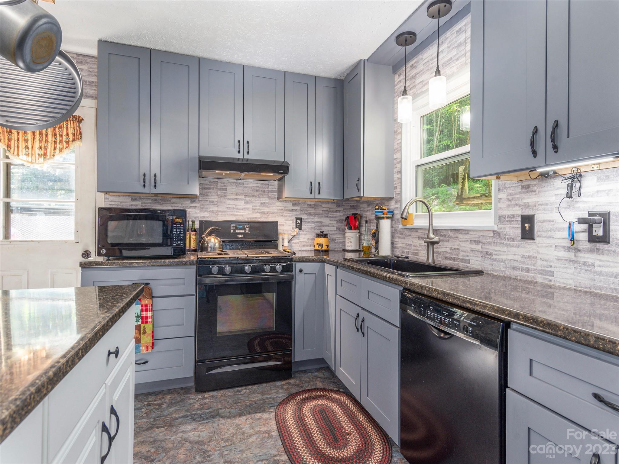 291 Dickinson Drive Clyde, NC 28721 - Photo 7 of 27 a kitchen with granite countertop a stove sink and cabinets