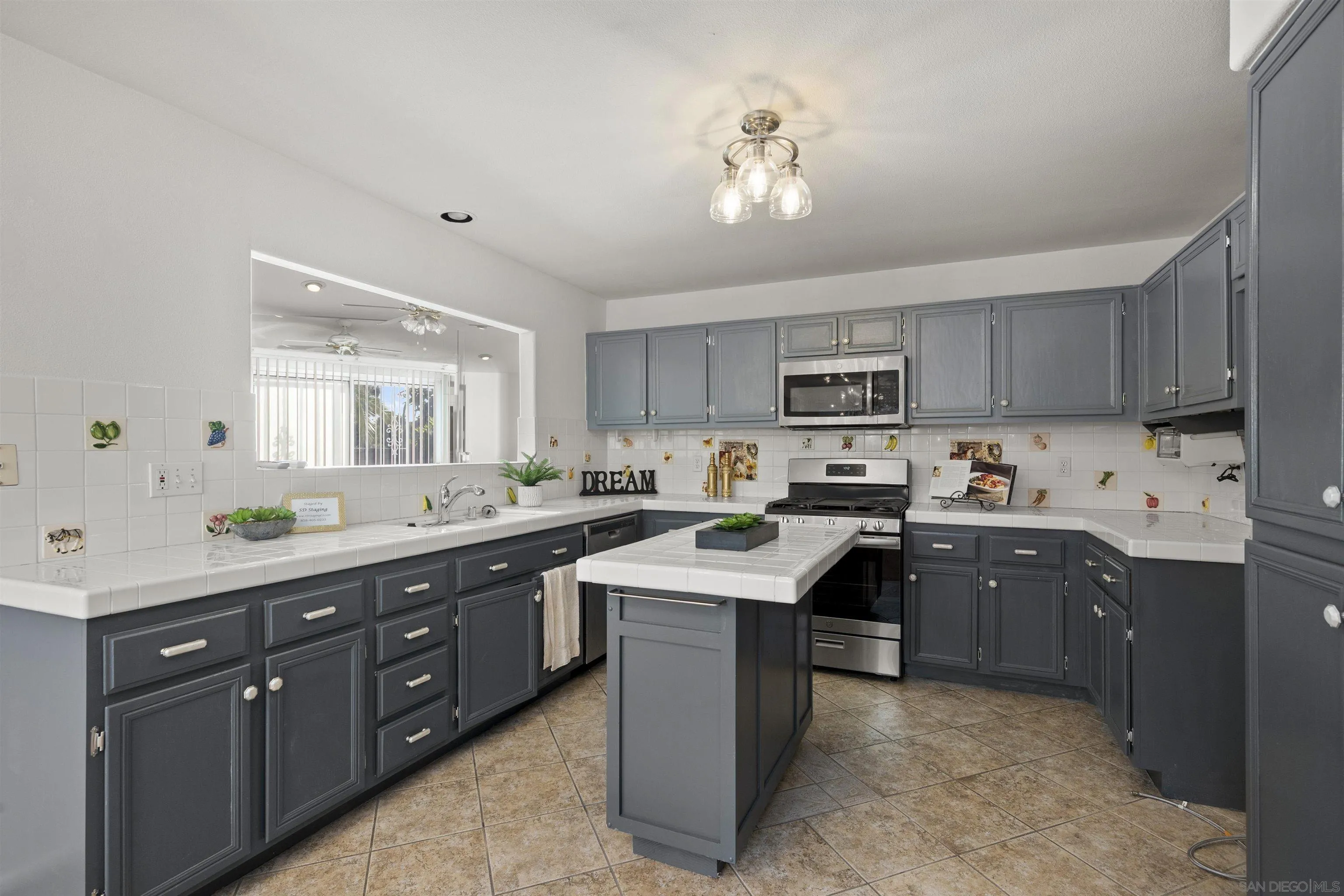 4815 Ebony Ridge Road San Diego, CA 92102 - Photo 16 of 45 a kitchen with sink a microwave and cabinets