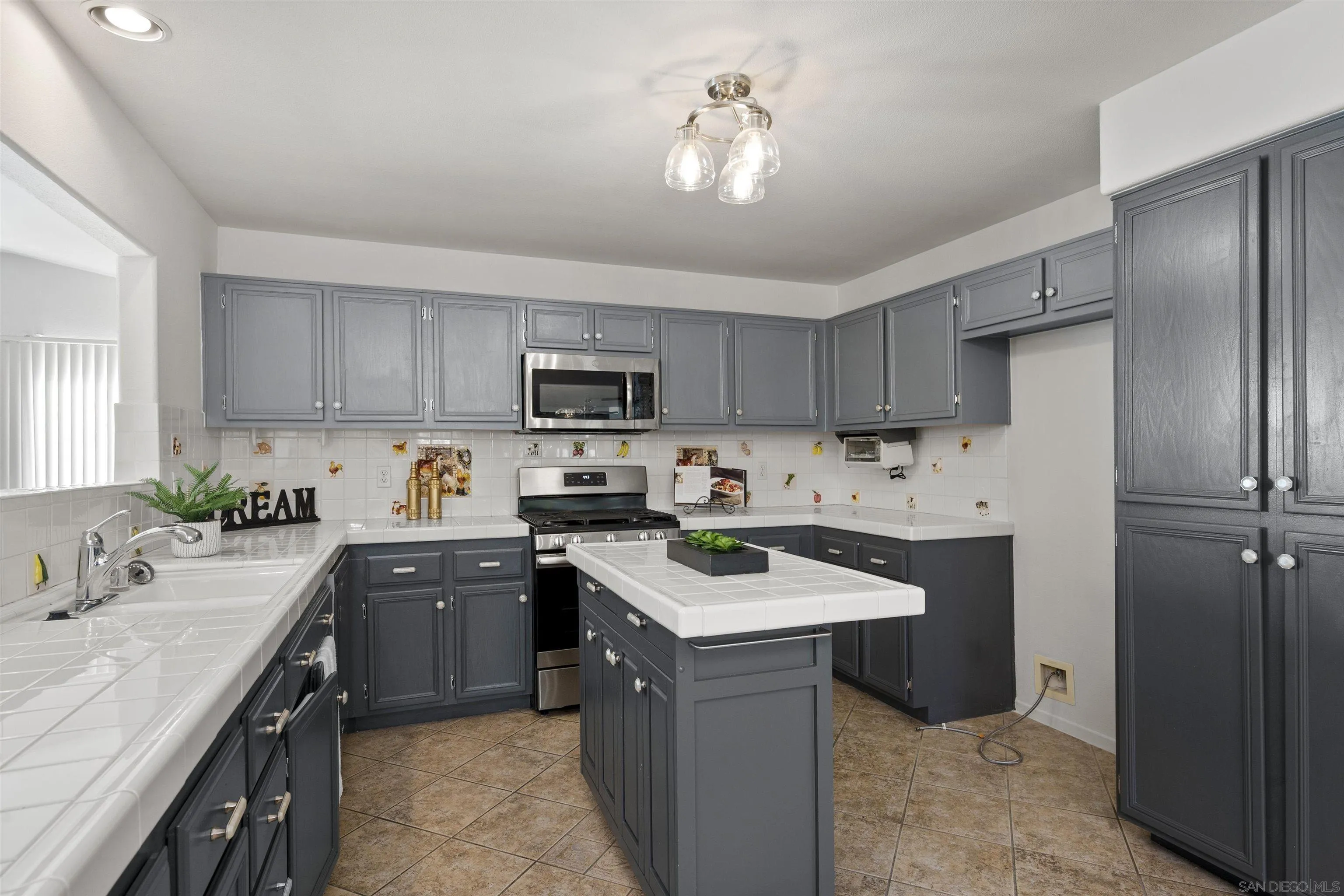 4815 Ebony Ridge Road San Diego, CA 92102 - Photo 17 of 45 a kitchen with a sink stainless steel appliances and view living room