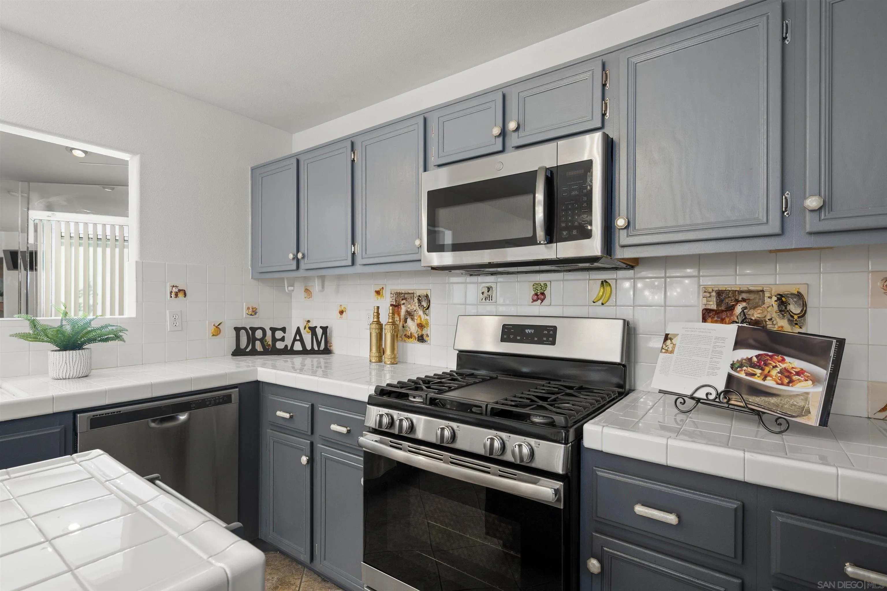 4815 Ebony Ridge Road San Diego, CA 92102 - Photo 18 of 45 a kitchen with granite countertop a stove top oven microwave and cabinets