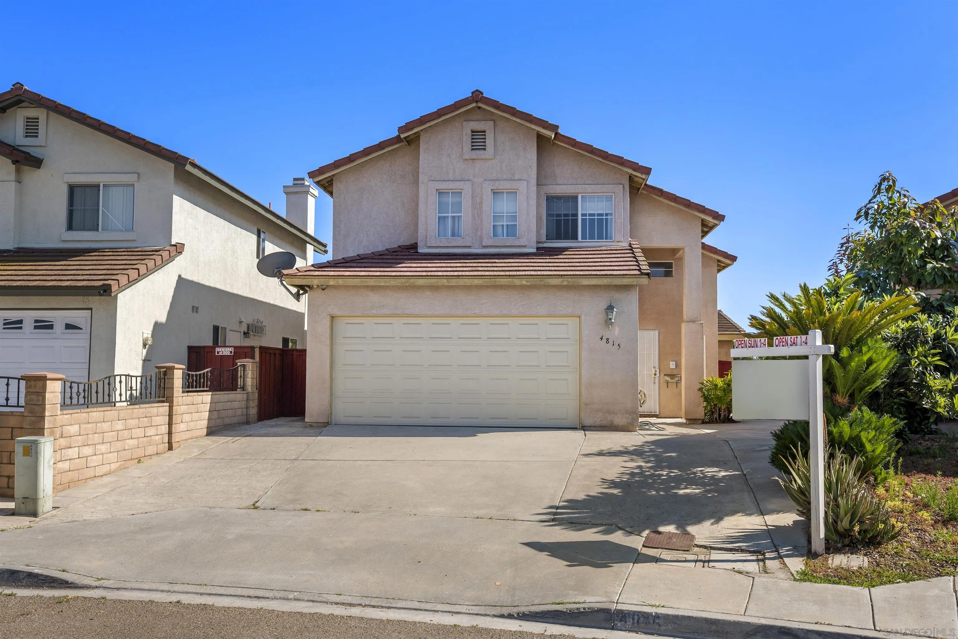 4815 Ebony Ridge Road San Diego, CA 92102 - Photo 2 of 45 a front view of a house with a yard and garage