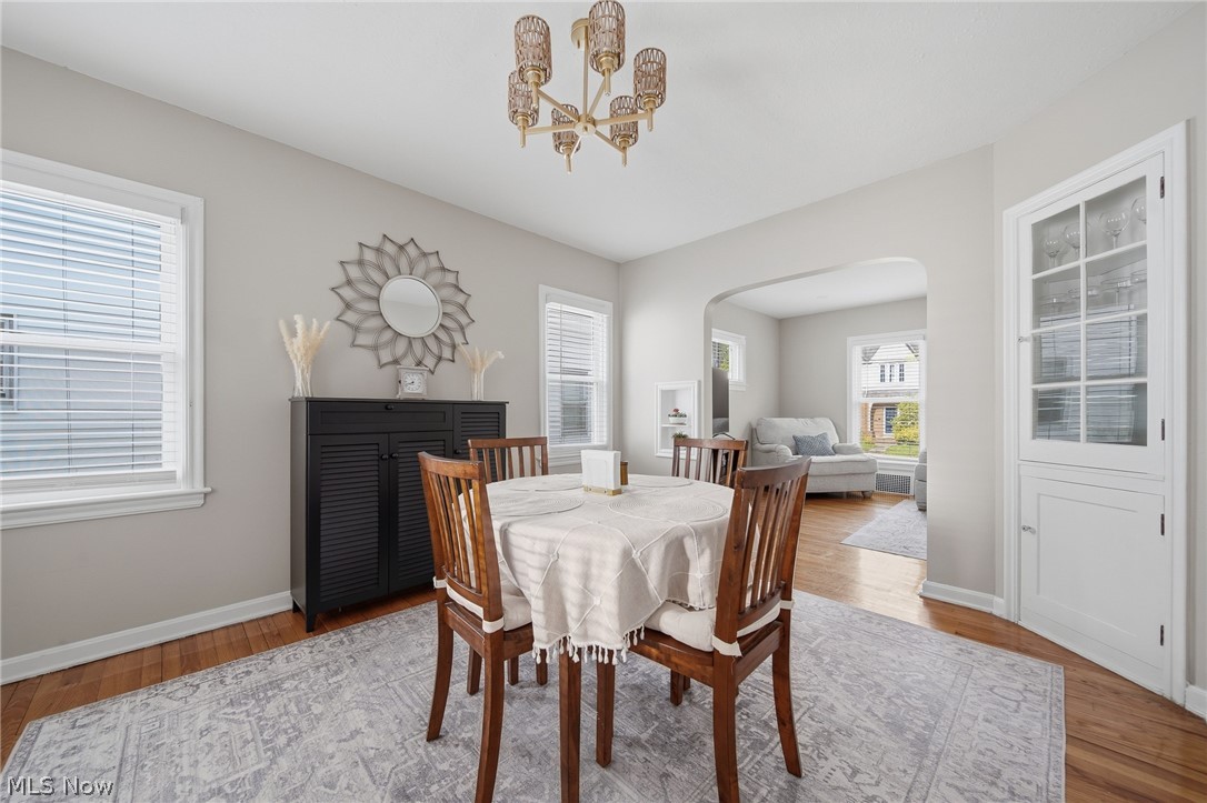 2231 Brockway Road University Heights, OH 44118 - Photo 11 of 46 Dining area featuring hardwood flooring, light gray wall paint, and a built-in corner cabinet with glass-paned doors