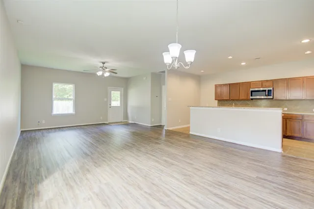 a view of a kitchen with a sink wooden floor and a large window