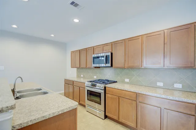 a kitchen with granite countertop white cabinets and stainless steel appliances
