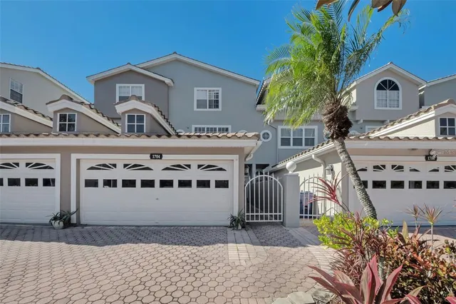 a kitchen with stainless steel appliances granite countertop a stove top oven a sink a dining table and chairs with wooden floor