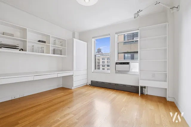 a view of an empty room with cabinet and stairs