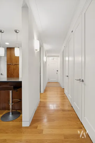a view of a hallway with wooden floor and staircase