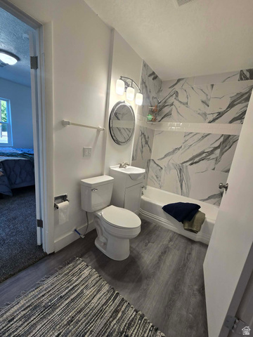 259 14th Street Ogden, UT 84404 - Photo 18 of 21 Bathroom with wood-finish flooring, a white vanity with an integrated sink, a white toilet, and a white bathtub