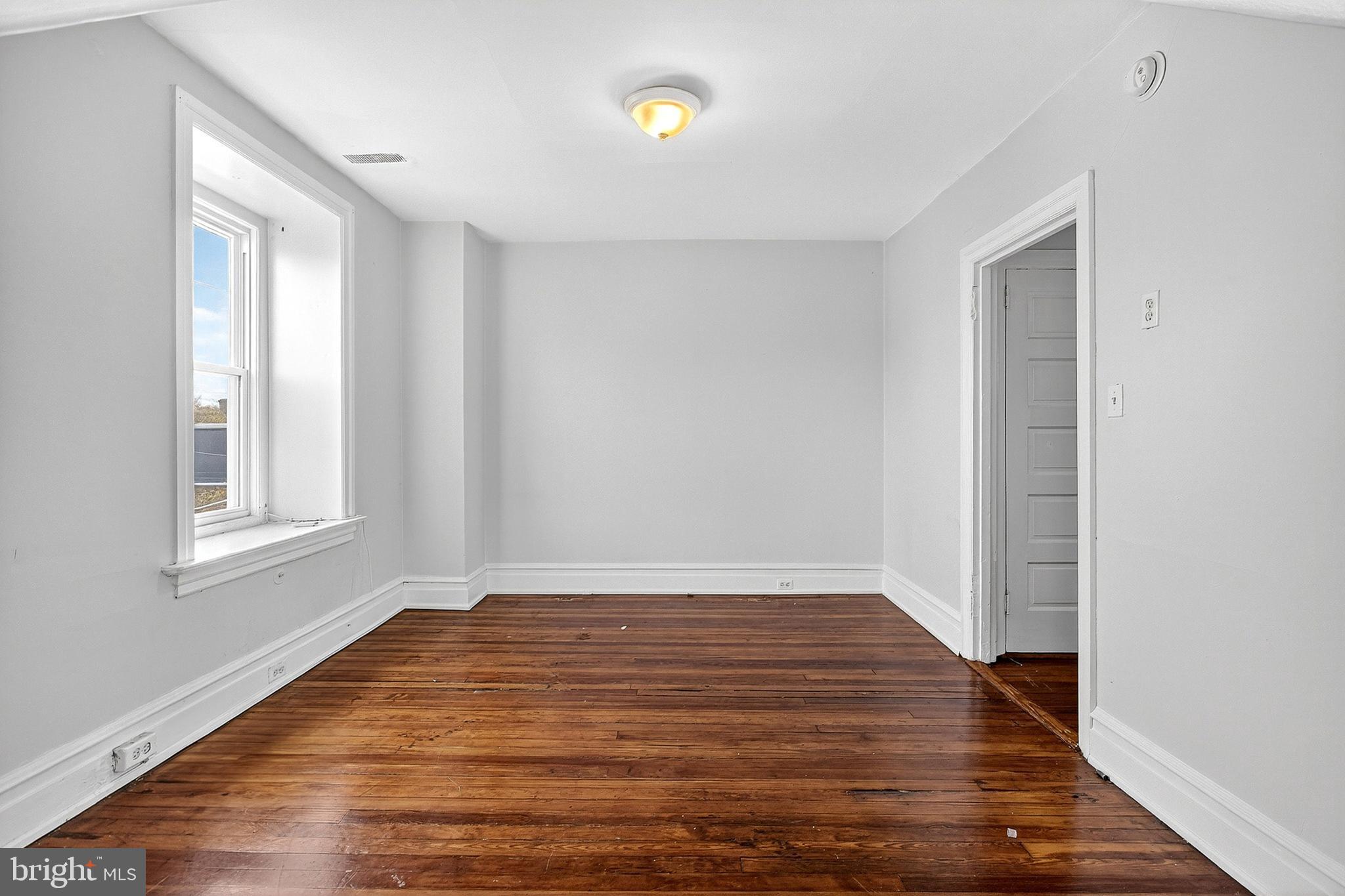 5506 Greene Street Philadelphia, PA 19144 - Photo 16 of 17 a view of an empty room with wooden floor and a window