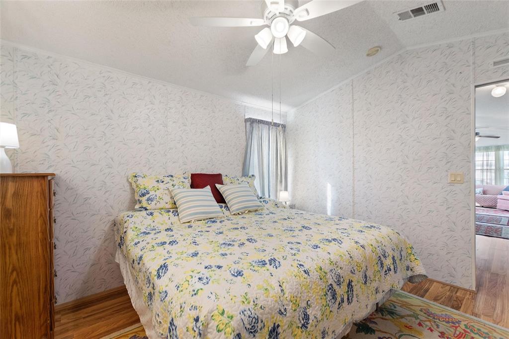 251 Patterson Road, Unit J19 Haines City, FL 33844 - Photo 14 of 30 a bedroom with a large bed and a chandelier