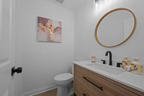 a bathroom with a sink mirror and toilet