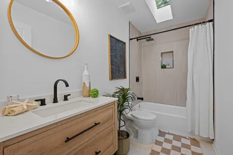 a bathroom with a sink a toilet and a mirror