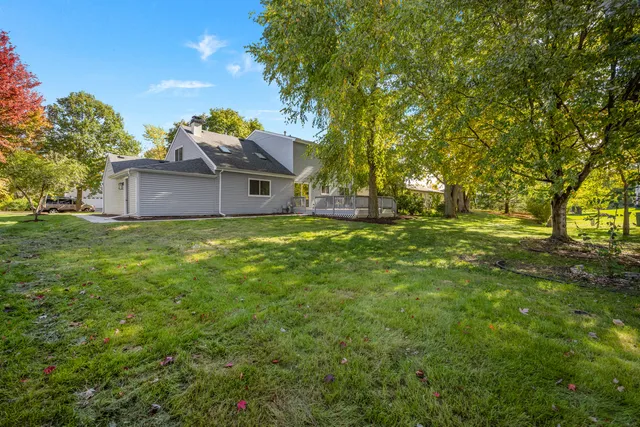 a view of a big house with a big yard and large trees