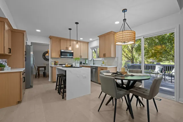 a kitchen with kitchen island a dining table and a chandelier