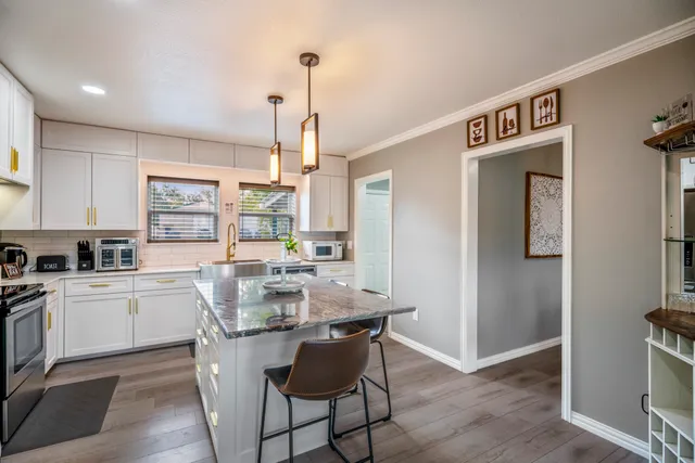 a kitchen with a dining table chairs and cabinets