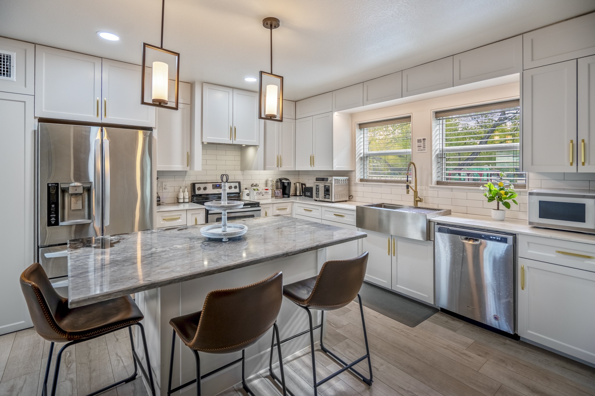 3207 Brownie Campbell Road Houston, TX 77086 - Photo 14 of 49 a kitchen with stainless steel appliances granite countertop a stove a refrigerator a sink a stove and white cabinets with wooden floor