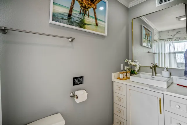 a bathroom with a sink mirror vanity and toilet
