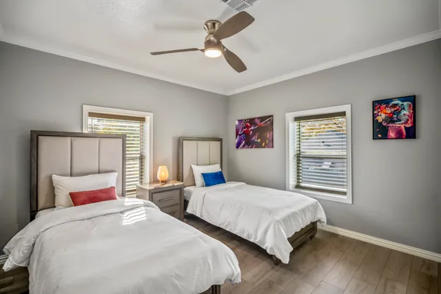 a bedroom with two beds and a chandelier