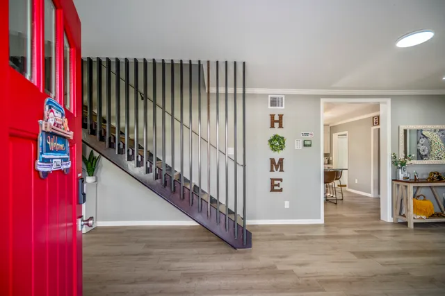 a view of hallway with wooden floor and stairs