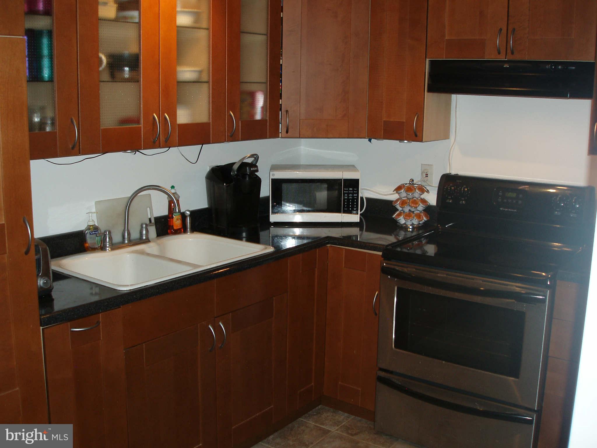 200 Cox Road Huntingtown, MD 20639 - Photo 24 of 27 a kitchen with granite countertop a stove top oven microwave and sink
