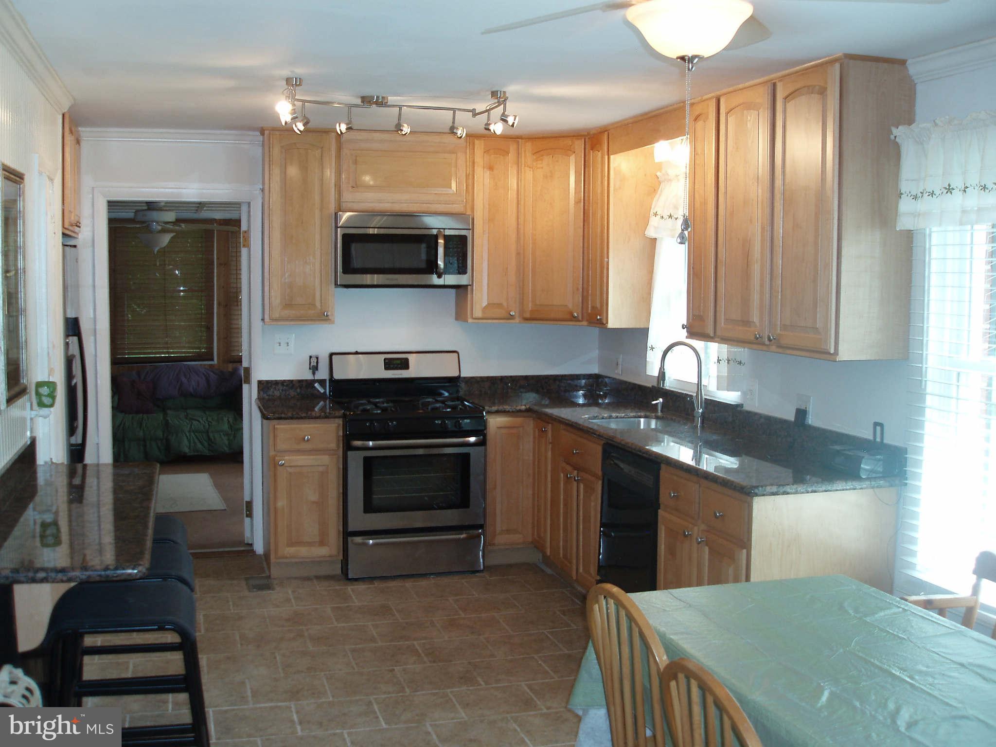200 Cox Road Huntingtown, MD 20639 - Photo 4 of 27 a kitchen with stainless steel appliances granite countertop a stove a sink and a microwave