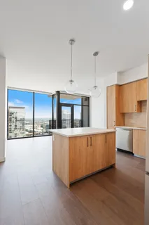 a large white kitchen with kitchen island a large counter top a sink a stove and a wooden floors
