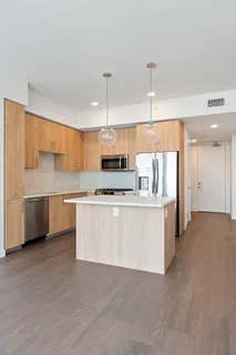 a kitchen with stainless steel appliances a stove top oven a sink dishwasher and a refrigerator