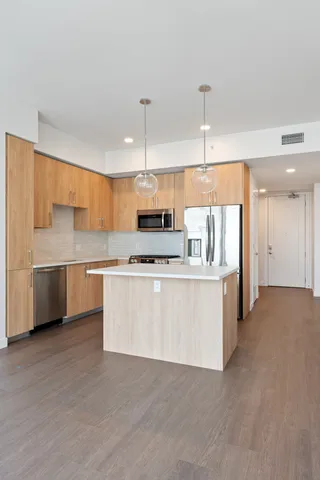 a kitchen with stainless steel appliances a stove top oven a sink dishwasher and a refrigerator