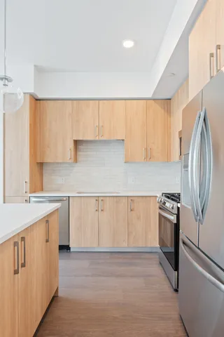 a kitchen with granite countertop white cabinets and stainless steel appliances