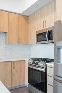 a kitchen with granite countertop cabinets stainless steel appliances and wooden floor
