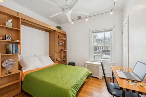 a bedroom with a bed and a chair with the book shelf