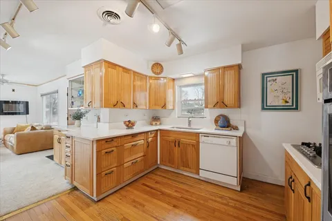 a kitchen with a sink cabinets and wooden floor
