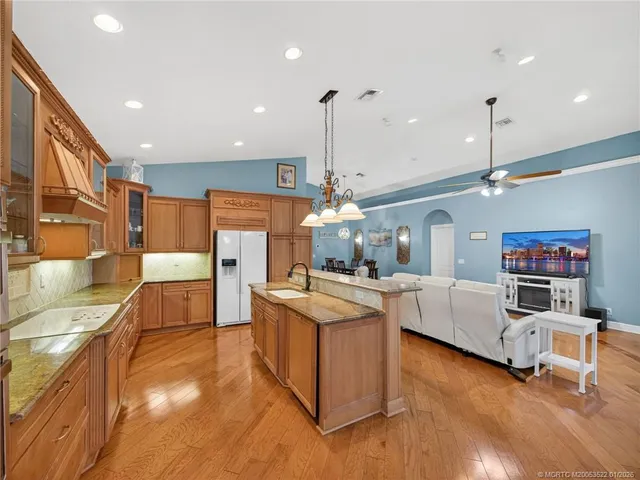 a kitchen with stainless steel appliances granite countertop a sink refrigerator and cabinets