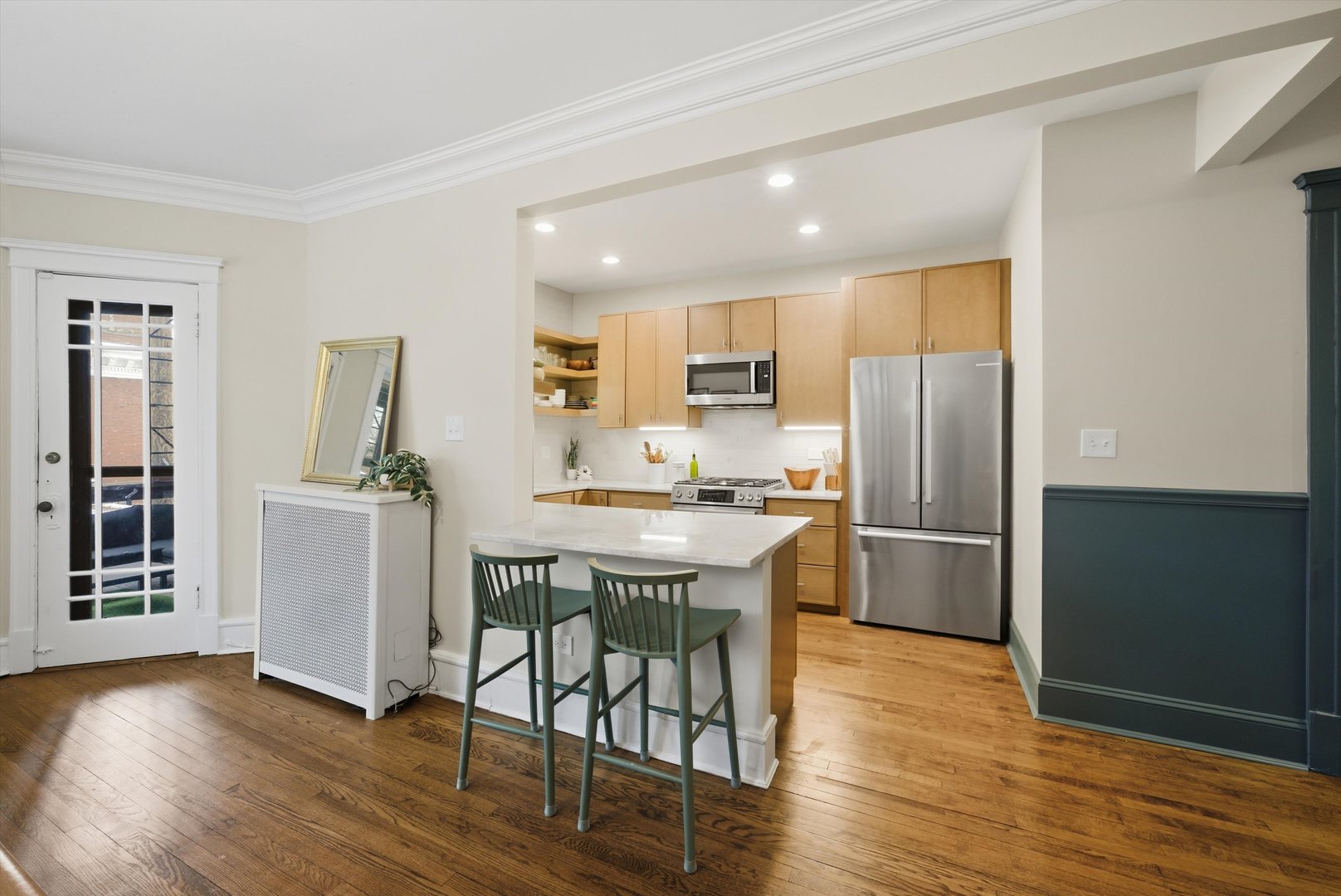 939 West Ainslie Street, Unit 2E Chicago, IL 60640 - Photo 15 of 47 a kitchen with a refrigerator a stove a sink and a dining table with wooden floor