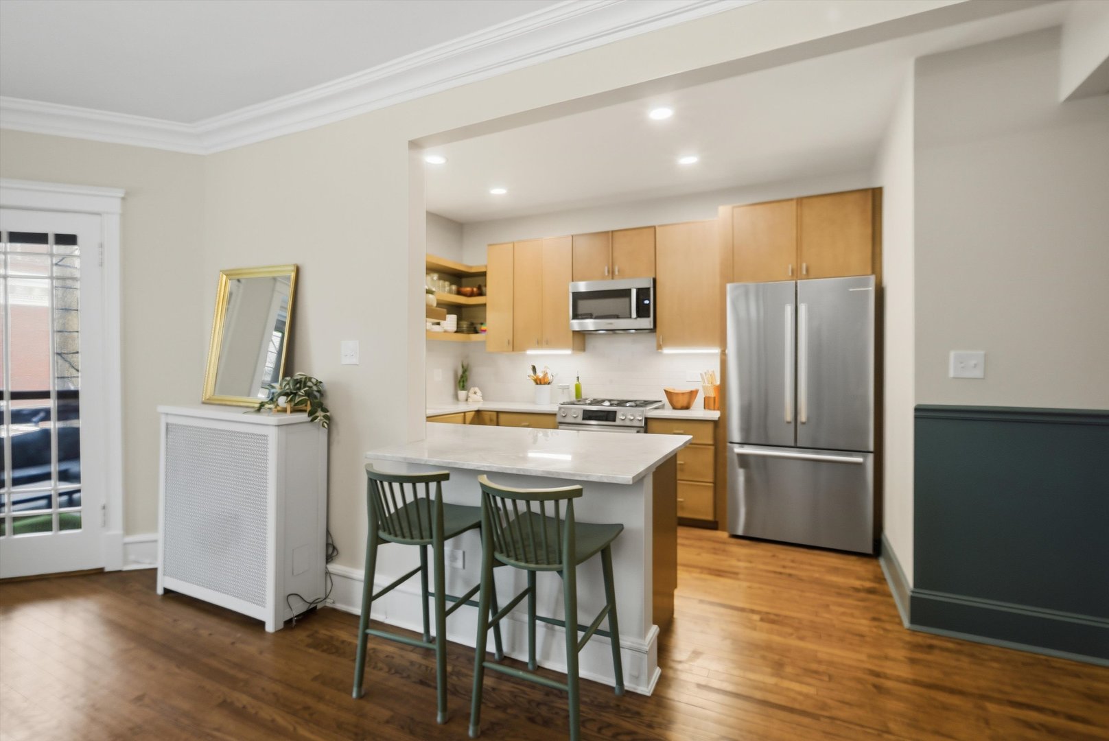 939 West Ainslie Street, Unit 2E Chicago, IL 60640 - Photo 16 of 47 a kitchen with a refrigerator a stove a sink and a dining table with wooden floor