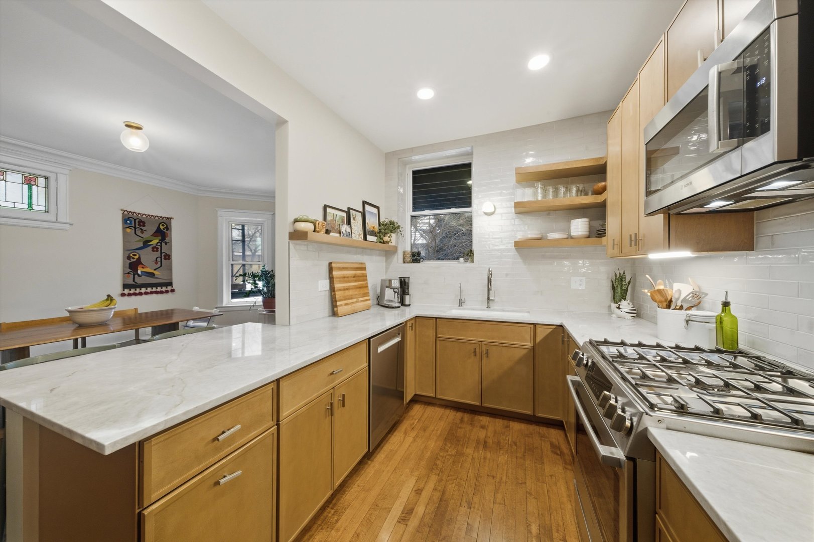 939 West Ainslie Street, Unit 2E Chicago, IL 60640 - Photo 22 of 47 a kitchen with stainless steel appliances granite countertop a lot of counter space and wooden floors