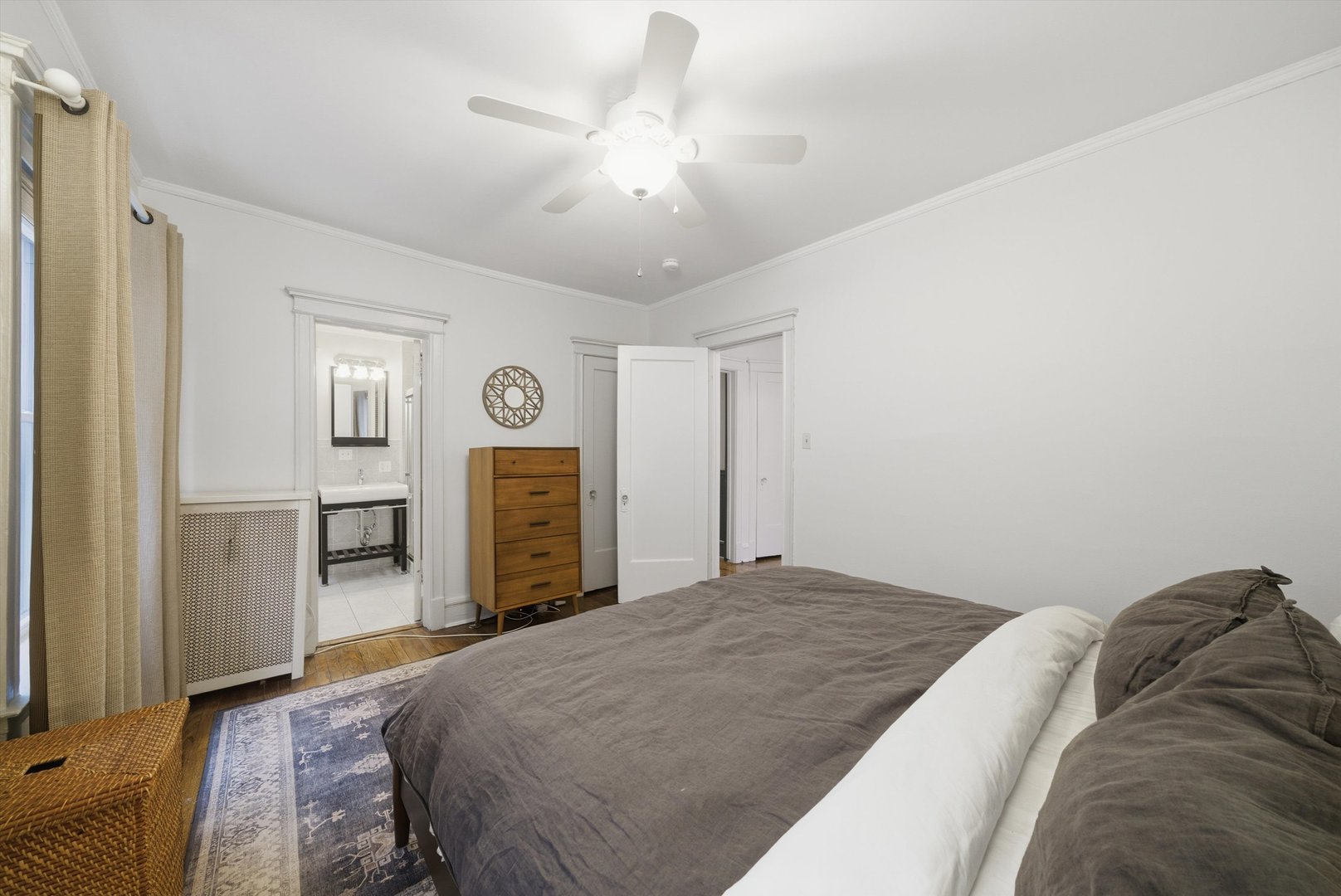 939 West Ainslie Street, Unit 2E Chicago, IL 60640 - Photo 29 of 47 a bedroom with a bed and a flat tv screen on dresser