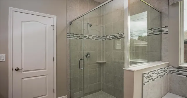 a bathroom with a shower a sink and mirror