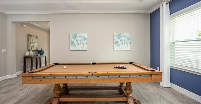 a room with pool table and windows