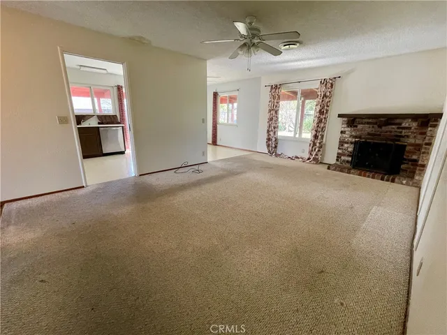 an empty room with windows and fireplace