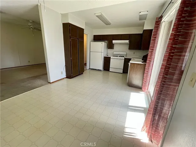 a view of kitchen with refrigerator stove and window