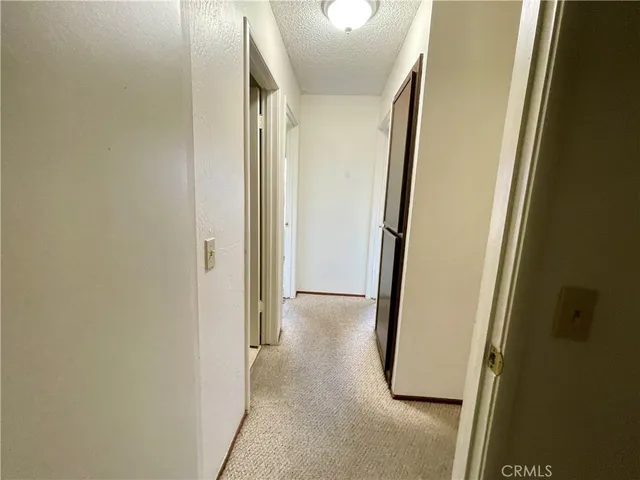 a view of a hallway with wooden floor and a door