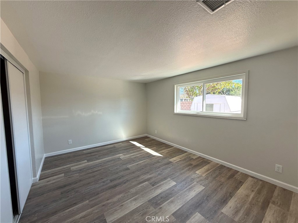 3445 Sparrow Circle Riverside, CA 92503 - Photo 16 of 41 a view of an empty room with wooden floor and a window