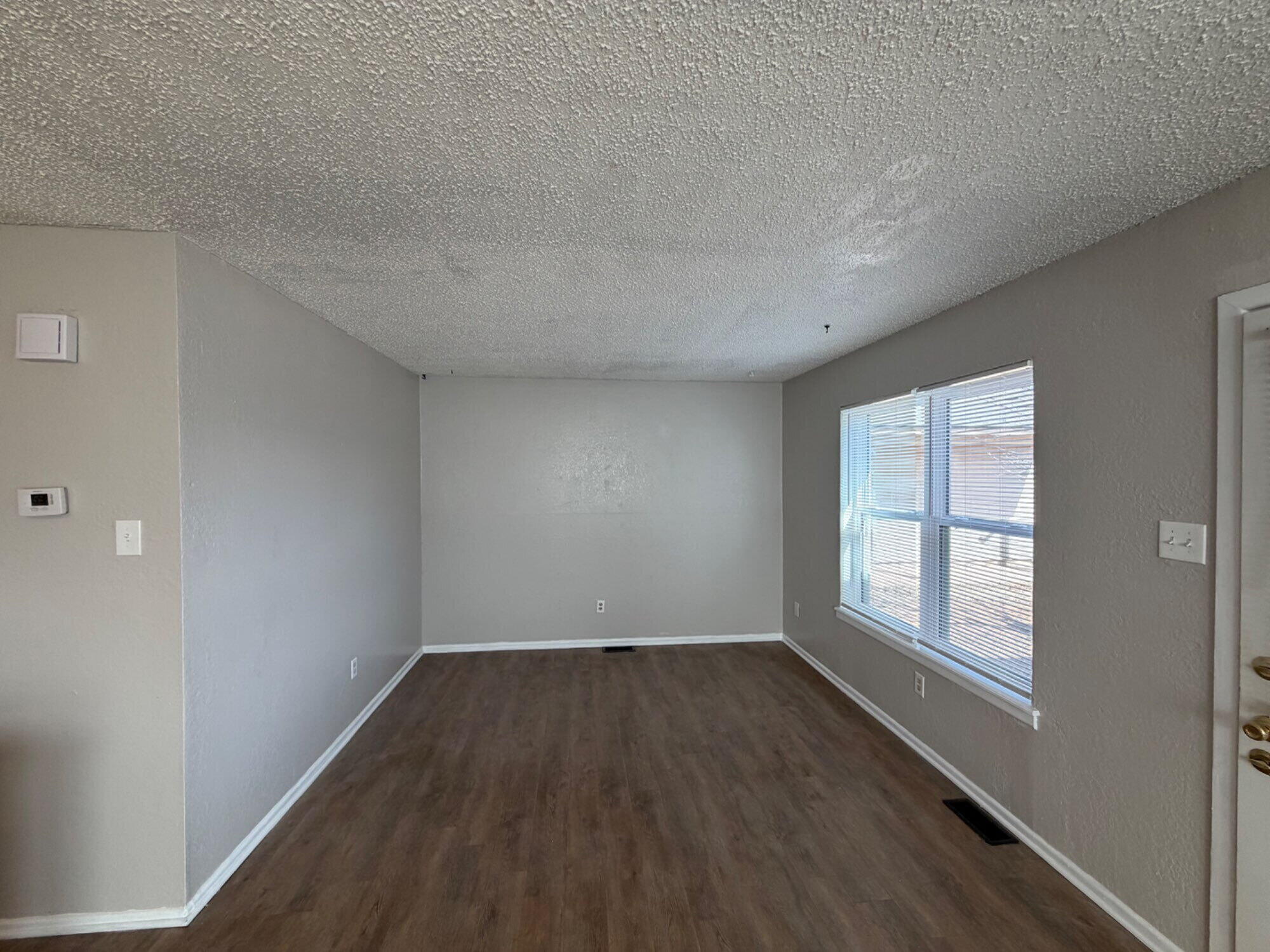 9604 Elgin Avenue, Unit B Lubbock, TX 79423 - Photo 2 of 12 wooden floor in an empty room with a window