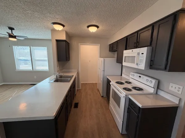 a kitchen that has a sink a stove and a wooden floor