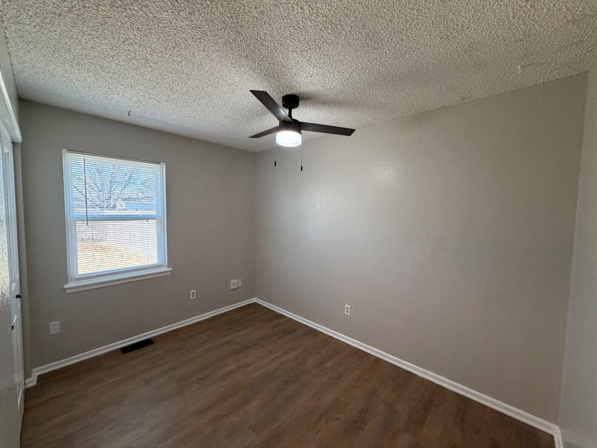 9604 Elgin Avenue, Unit B Lubbock, TX 79423 - Photo 9 of 12 an empty room with wooden floor and ceiling fan